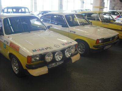 C-Promis: Kadett C Coupé GT/E, links rennfertig, daneben Serie. Rechts im Hintergrund die Rallye-Monte-Carlo-Legende Kadett B